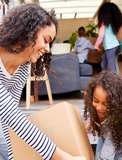 young family packing boxes into moving van